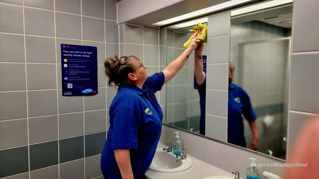 Cleaning With Meaning cleaner polishing a washroom mirror in Maidstone